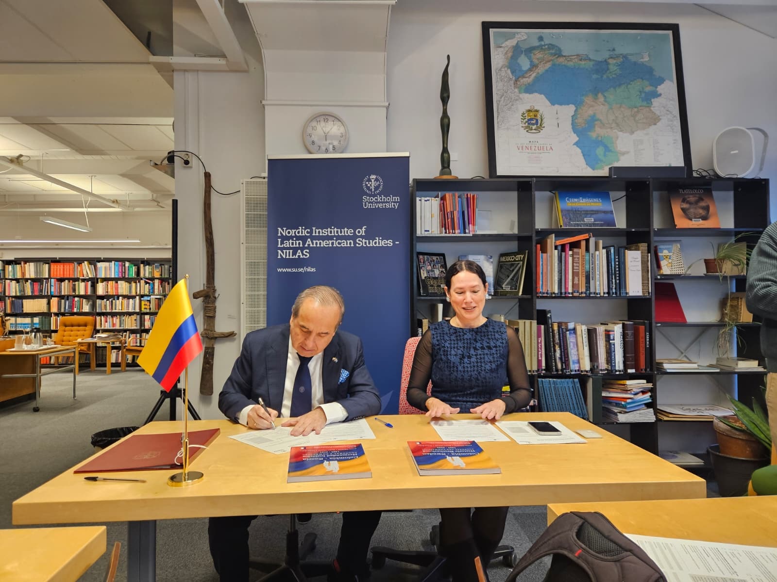 Buena noticia para la comunidad estudiantil colombiana. El día de hoy, jueves 11 de diciembre de 2025, el Embajador de Colombia Guillermo Francisco Reyes González junto con la Directora del Instituto Nórdico de Estudios Latinoamericanos de la Universidad de Estocolmo, Sra Thais Machado-Borges suscribieron el “Convenio de Cooperación Académica para la realización de Pasantías”.   Este instrumento, que cuenta con la aprobación de la Secretaria General de la Cancillería Colombiana permitirá, a partir de hoy, que los estudiantes colombianos (as) del NILAS puedan no solo realizar sus pasantías sino apoyar con su conocimiento la labor que adelanta la Embajada de Colombia en Suecia y la Oficina Comercial de ProColombia.   Este Convenio refleja los esfuerzos bilaterales por promover la cooperación en el ámbito de la educación superior, así como el deseo de la Embajada de buscar nuevas y más oportunidades para nuestra comunidad.  Esperamos recibir pronto las primeras aplicaciones por conducto del NILAS”.